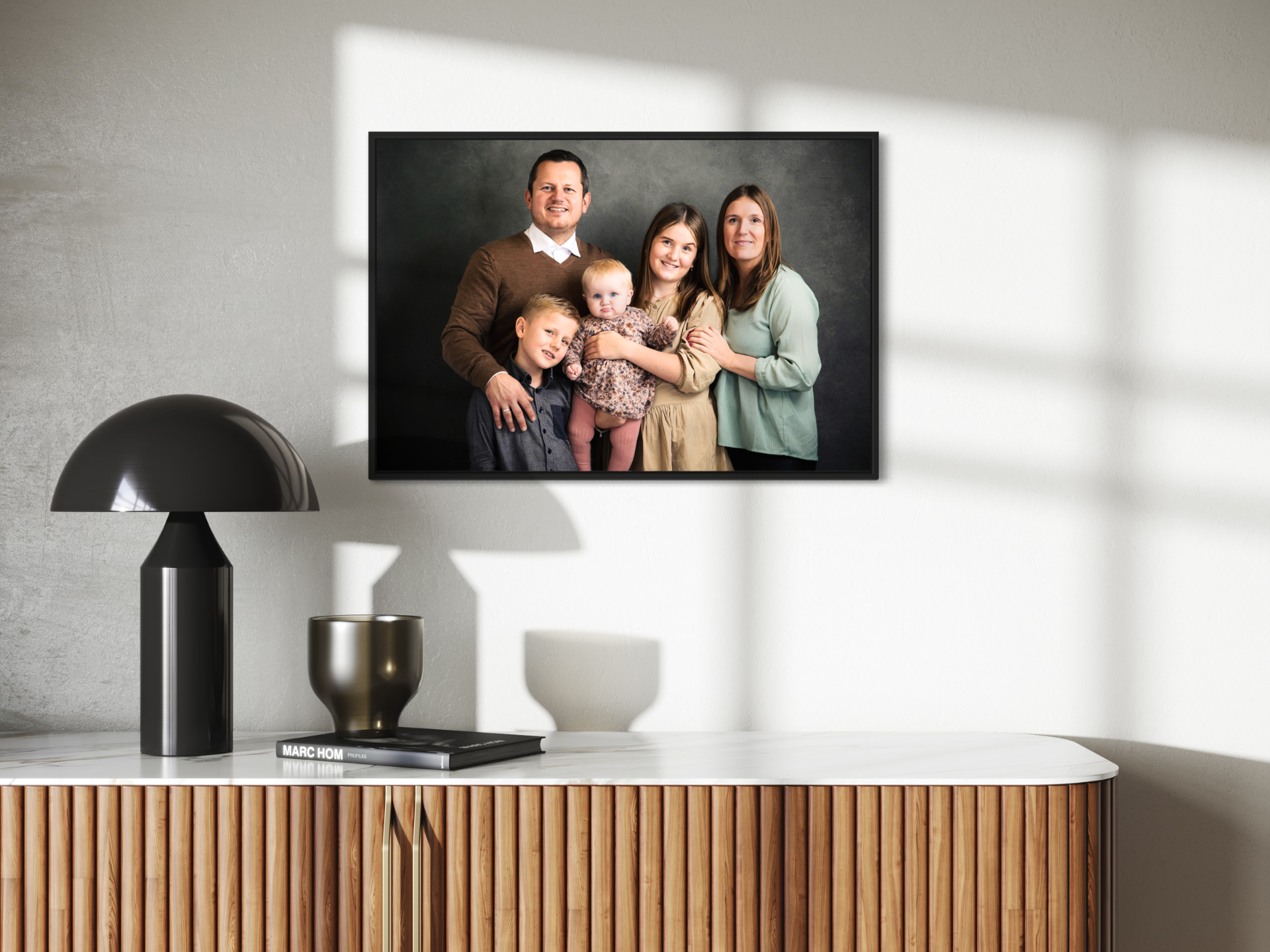 Storfamilieportræt i sort ramme over skænk - studiefotografering Nordjylland
